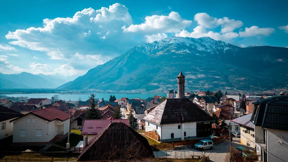 Carska džamija s drvenom munarom u Plavu, s jezerom i snježnim planinama u pozadini
